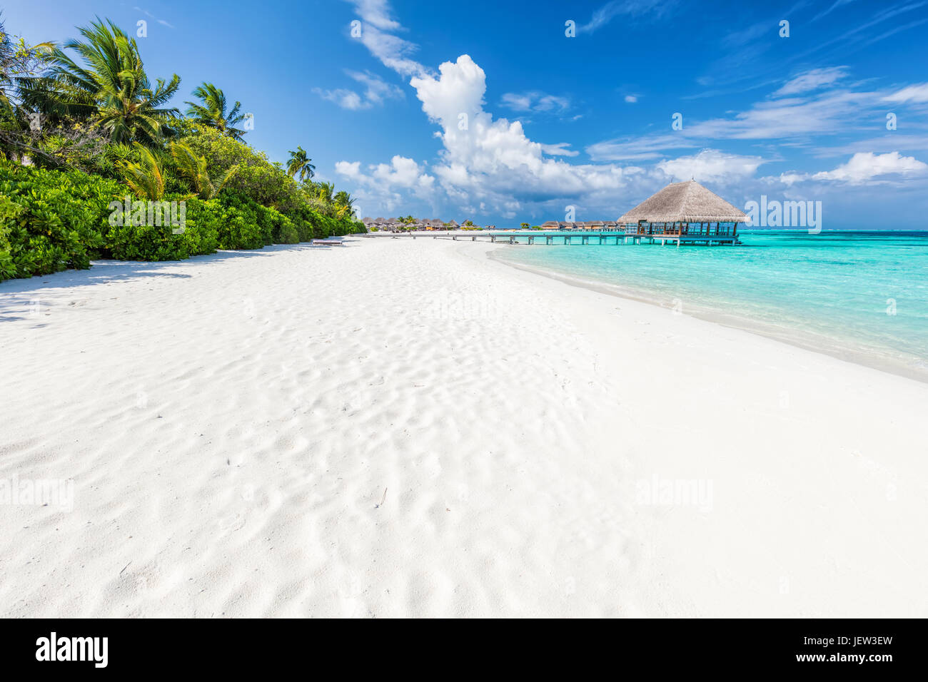 Ampia spiaggia di sabbia su un isola tropicale delle Maldive. Palme da cocco e acqua lodge sull Oceano Indiano. Foto Stock