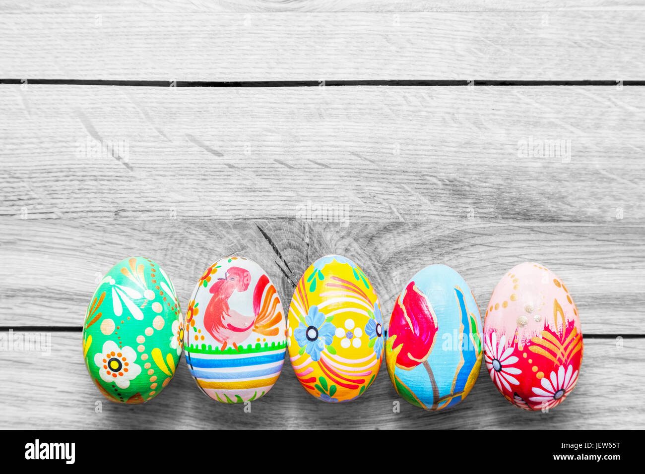 Pasqua uova artigianali dipinte con colori vivaci fantasie floreali collocato su un tavolo di legno. Foto Stock