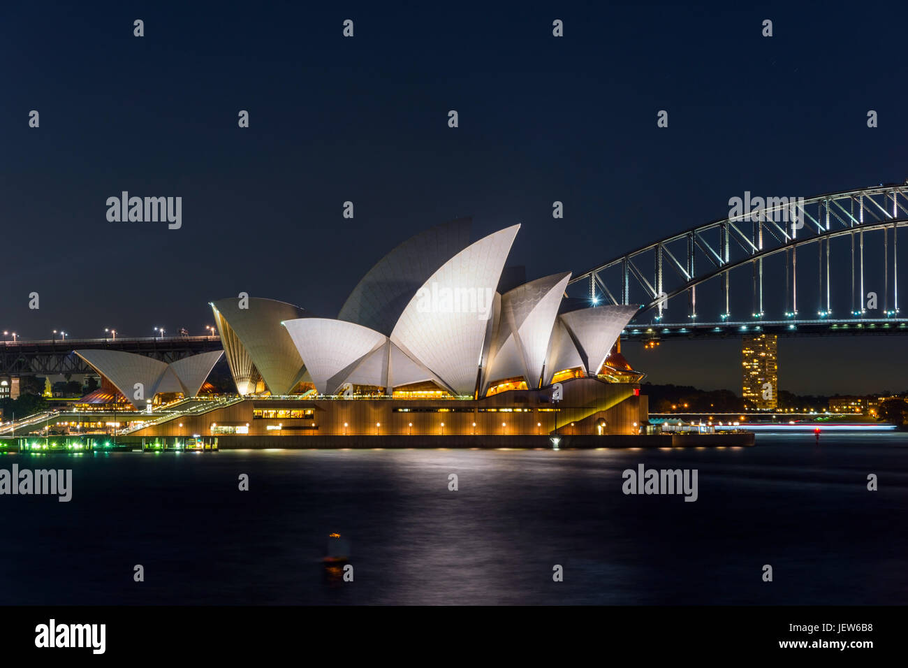 Vista sul teatro dell'opera di Sydney e Harbour Bridge di notte, una lunga esposizione Foto Stock