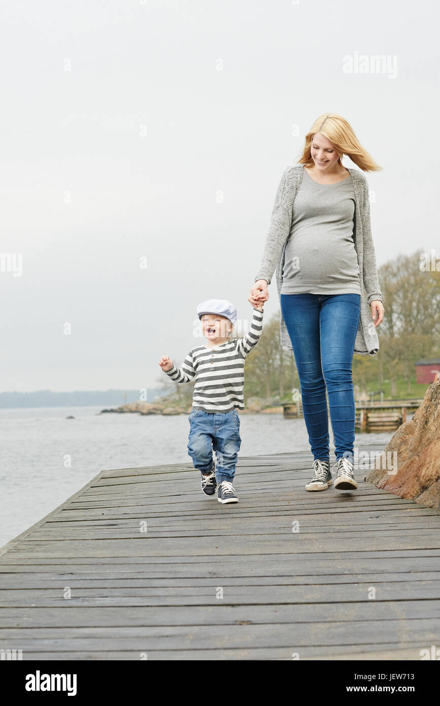 Donna con figlio camminando sul molo Foto Stock