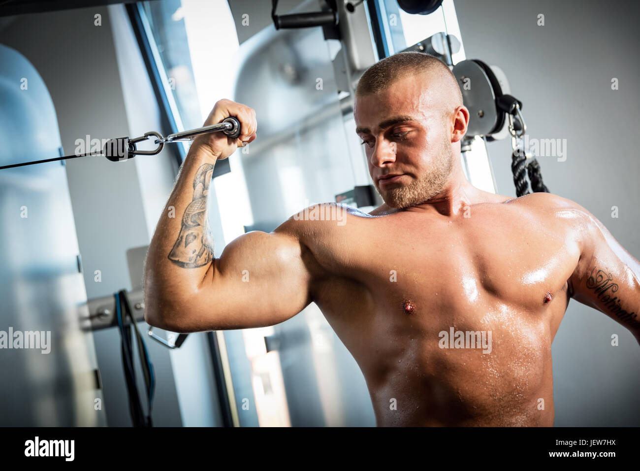 Muscolare, uomo forte lavora con attrezzature da palestra . Sport e bodybuilding concetto. Foto Stock