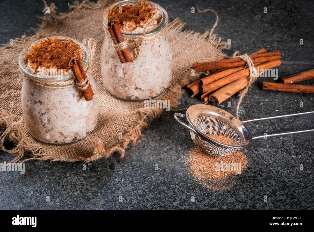 Spagnolo, Sud Americana, Messicana dessert. Sweet porridge, budino di riso. Arroz con leche. In porzionato giare, decorata con cannella e zucchero. Su un da Foto Stock