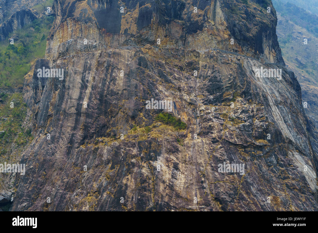 Picco roccioso sul circuito di Annapurna tra chamje e tal. una strada scavata nella roccia di fronte può essere visto nella parte superiore del picco. Foto Stock