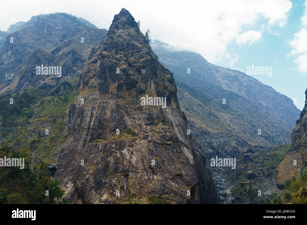 Picco roccioso sul circuito di Annapurna tra chamje e tal. una strada scavata nella roccia di fronte può essere visto nella parte superiore del picco. Foto Stock