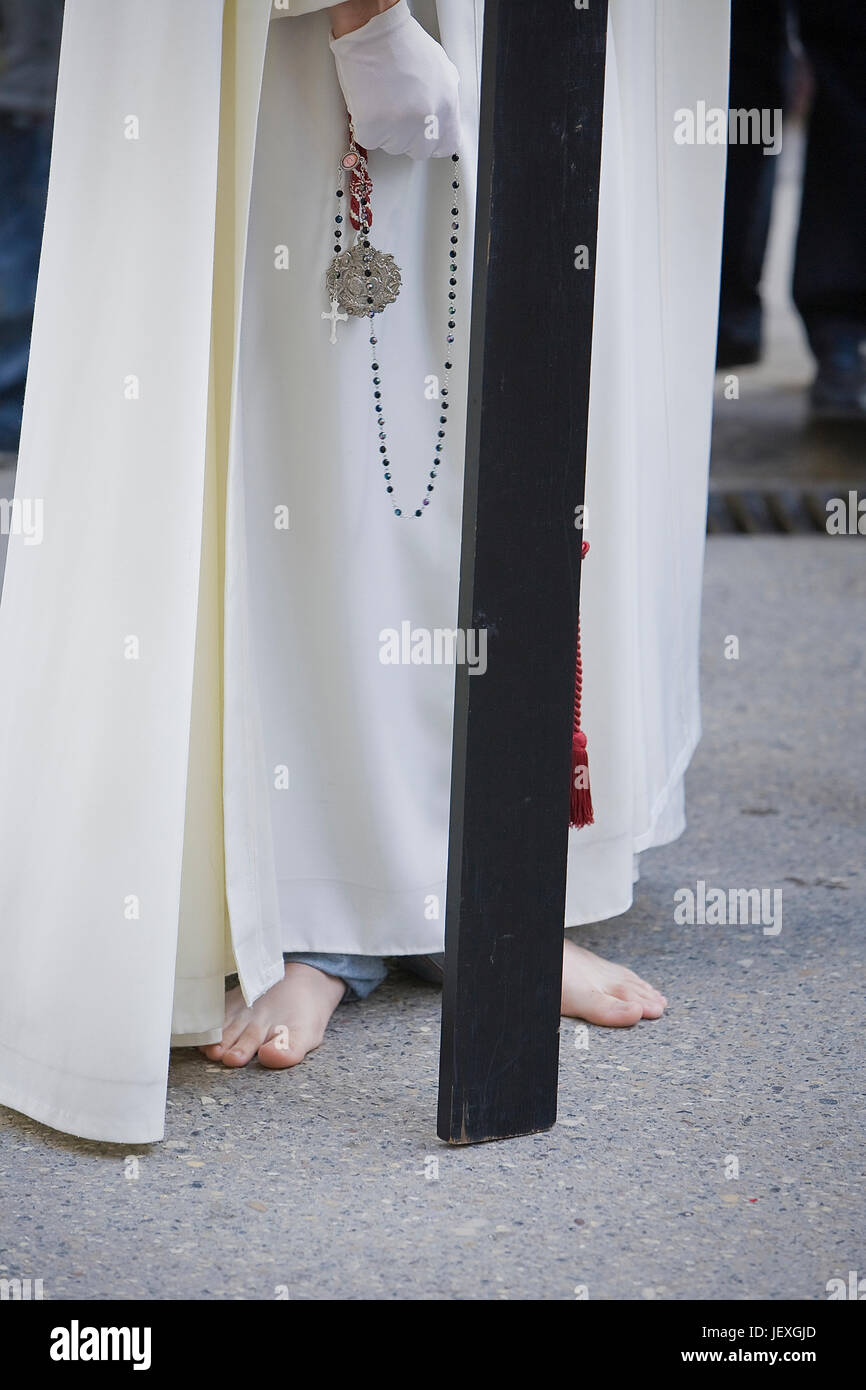 A piedi nudi penitente fare penitenza con una croce di legno in una settimana Santa processione, Venerdì Santo, Linares, JaŽn provincia, Spagna Foto Stock