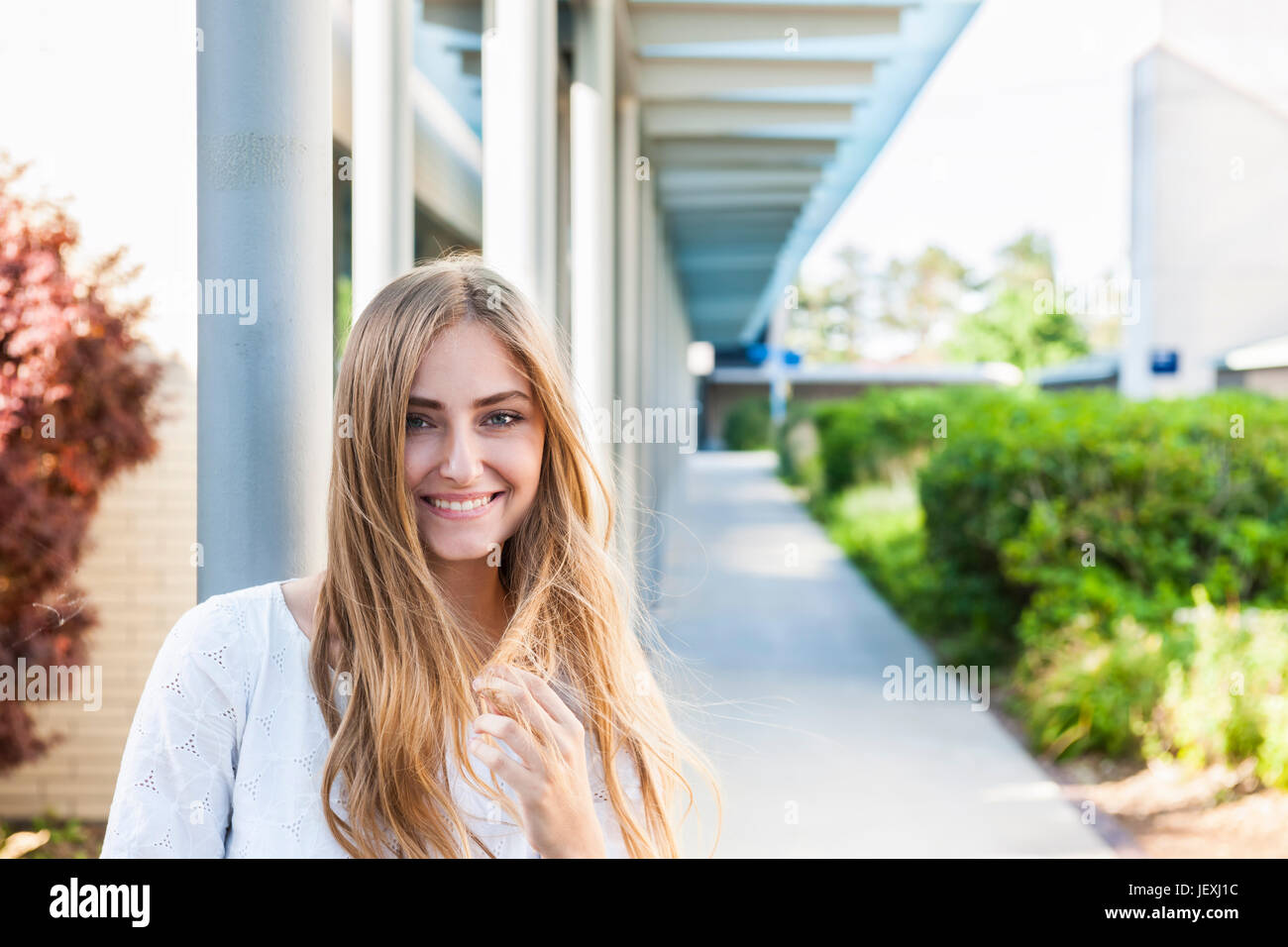 Sorridente giovane donna come università o studente di college del campus al di fuori Foto Stock