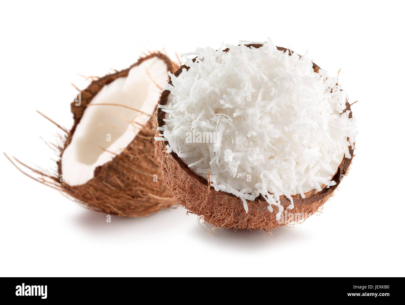 Due metà di noce di cocco con noci di cocco in scaglie isolate su uno sfondo bianco. Foto Stock