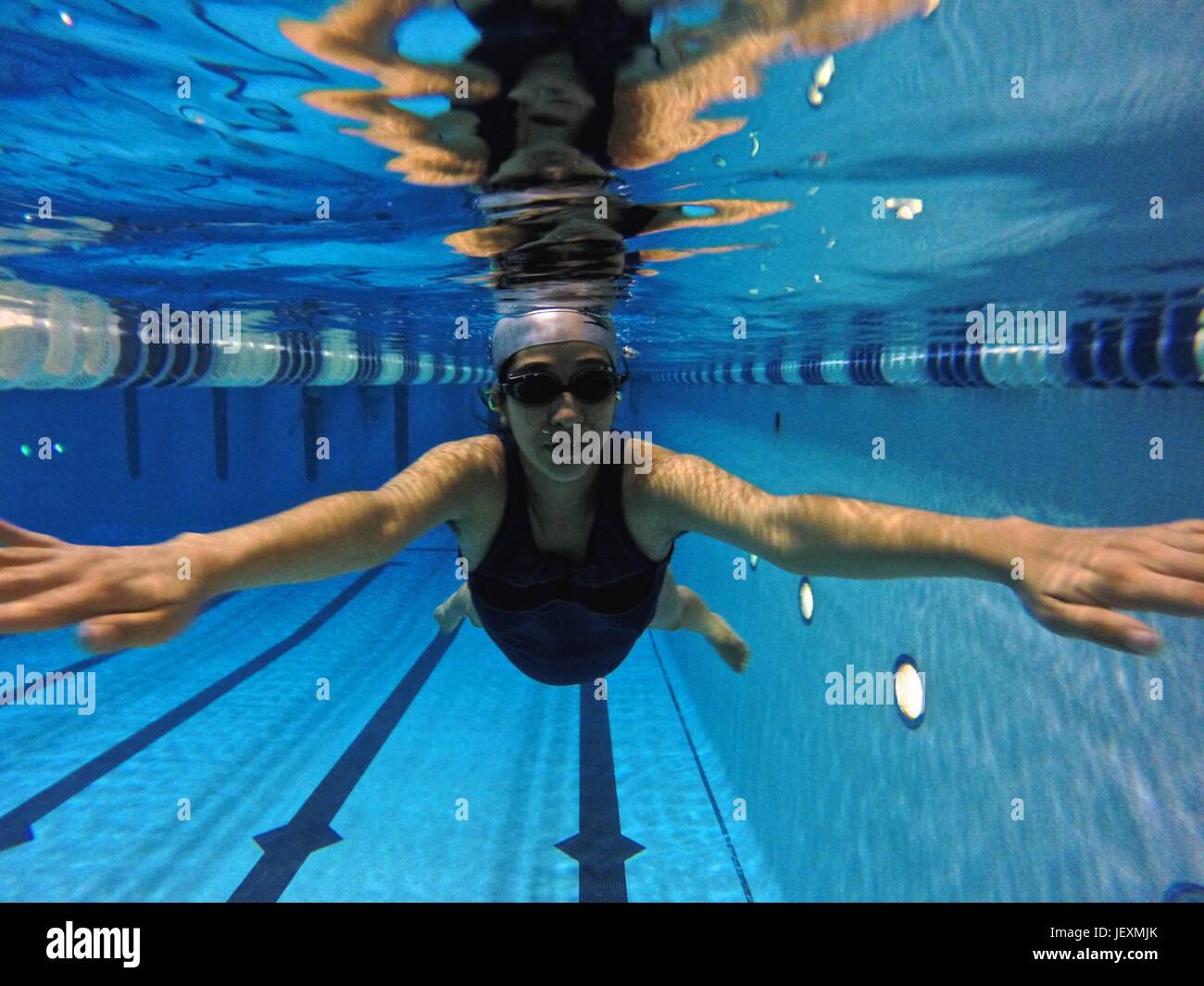 A 37 settimane di donna incinta nuota giri in una piscina coperta. Foto Stock