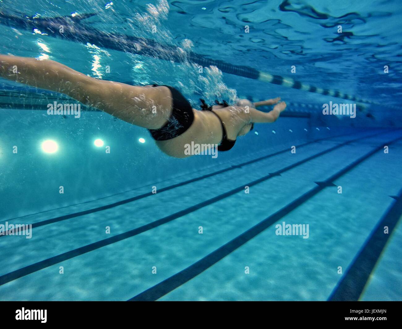 A 37 settimane di donna incinta nuota giri in una piscina coperta. Foto Stock