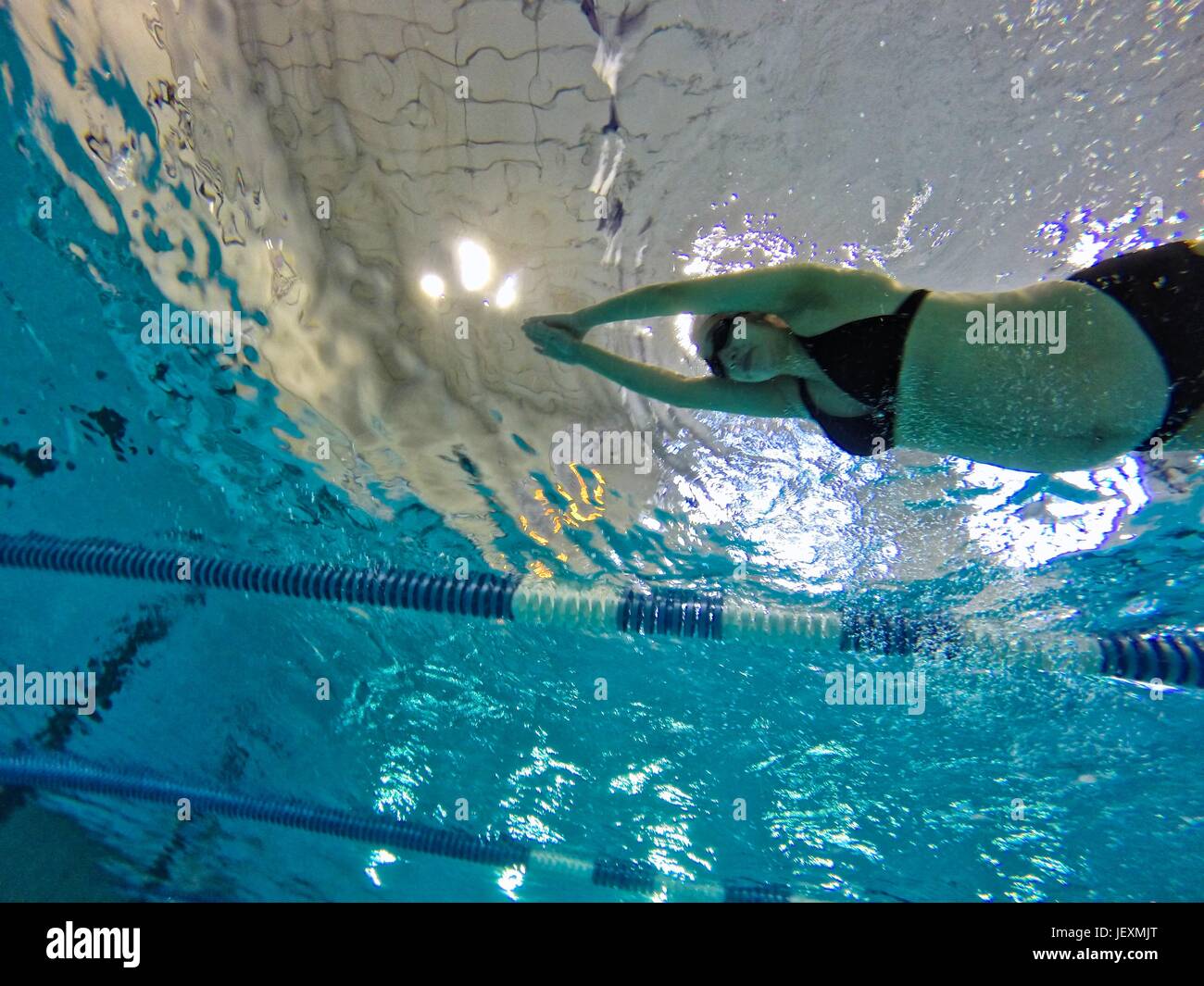 A 37 settimane di donna incinta nuota giri in una piscina coperta. Foto Stock