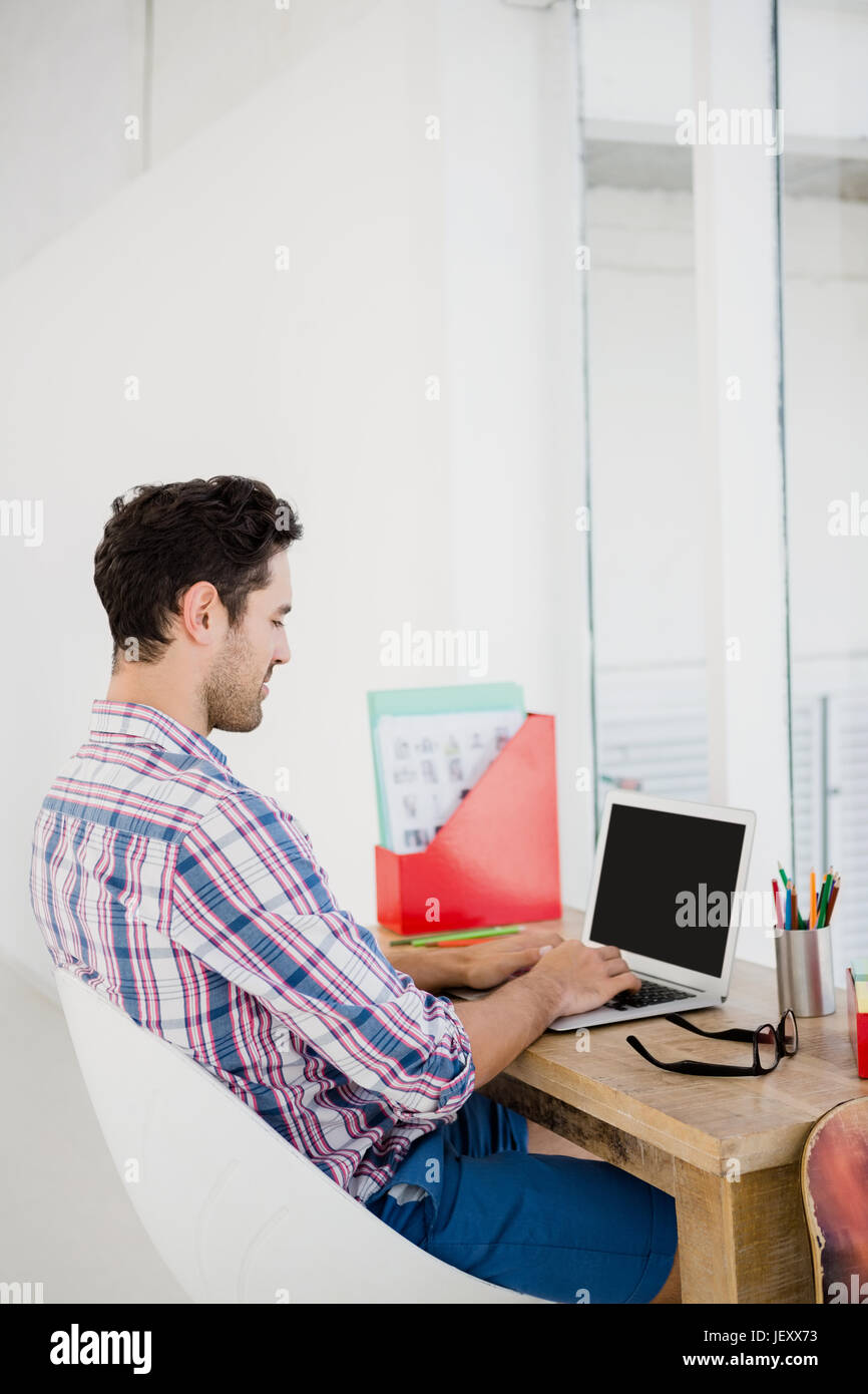 Giovane uomo che lavora alla sua scrivania Foto Stock