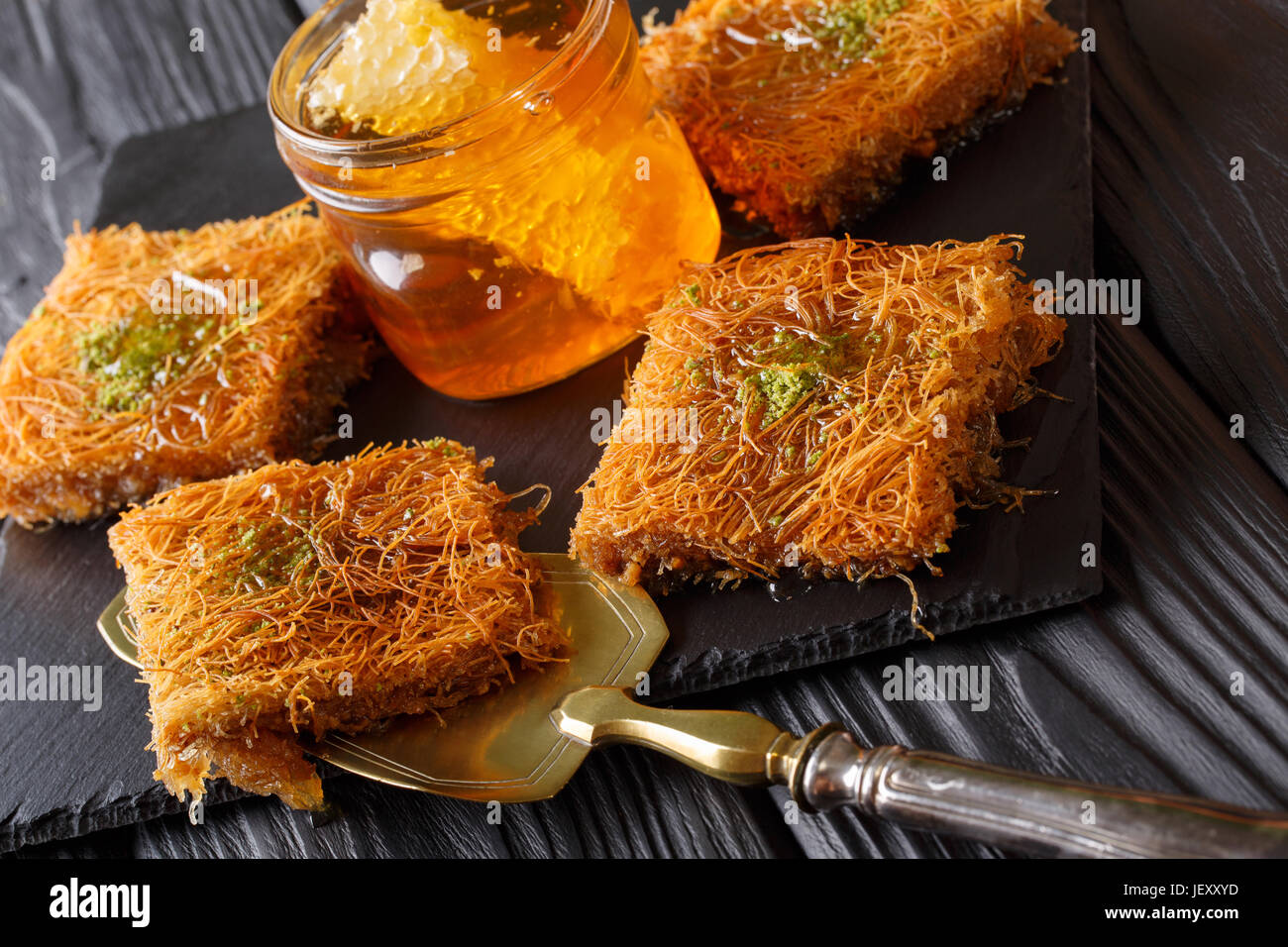 Kataif torta con pistacchi e miele fresco close-up su una tabella. Posizione orizzontale Foto Stock
