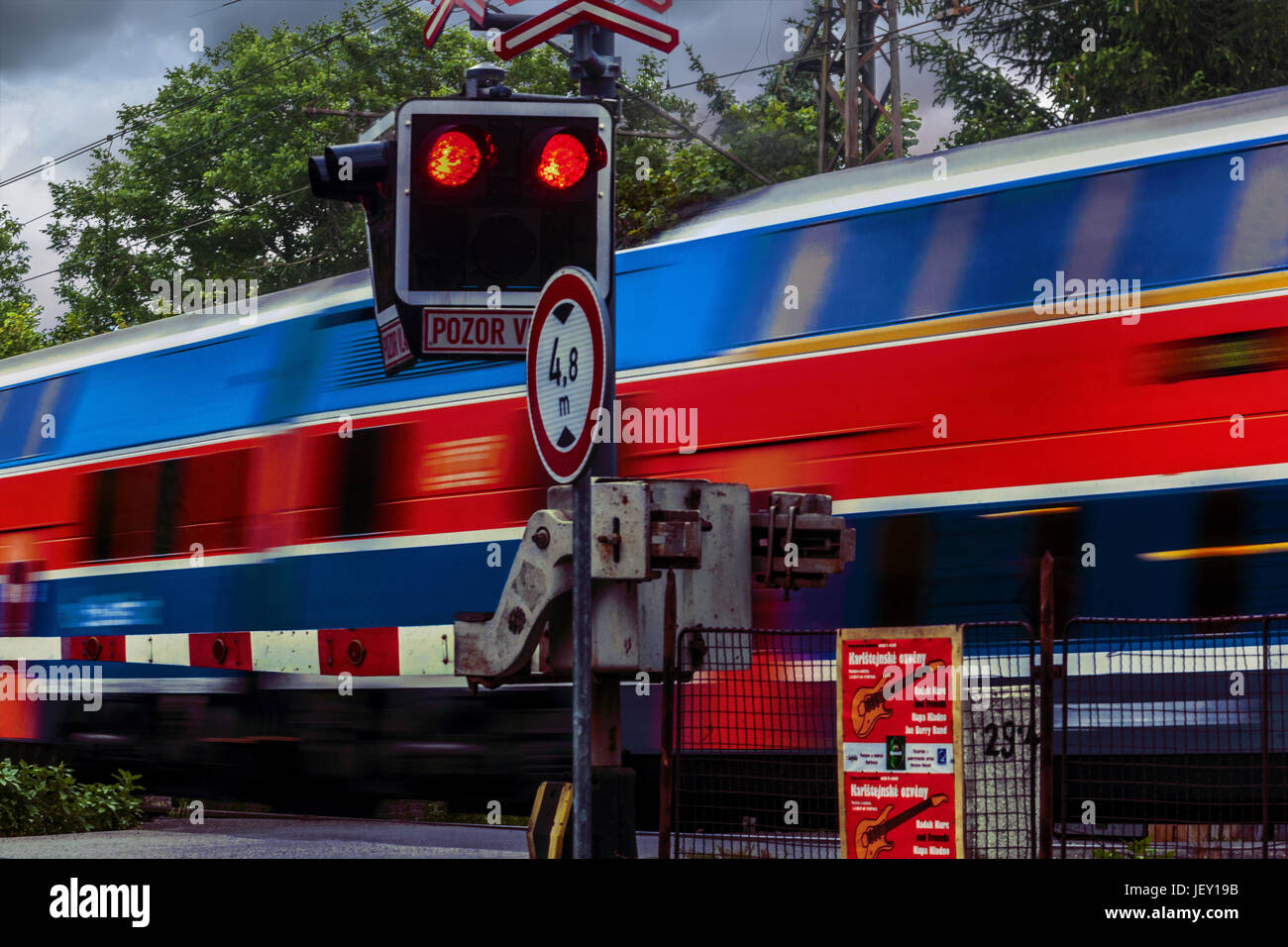Treno che supera un passaggio a livello con il rosso semaforo lampeggiante, attraversamento ferroviario Repubblica Ceca, Europa Foto Stock