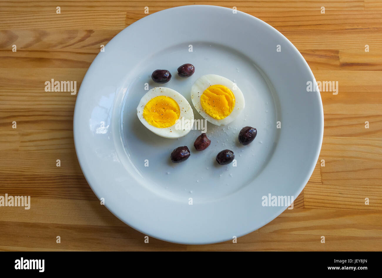 Un antipasto di uova sode e olive su un piatto bianco Foto Stock