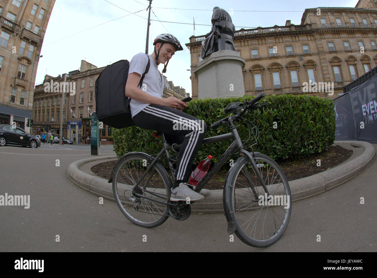 Giovane ragazzo consegna bike ciclista Uber Consegna del cibo scrivere messaggi in attesa per il lavoro sorridenti in attesa Foto Stock