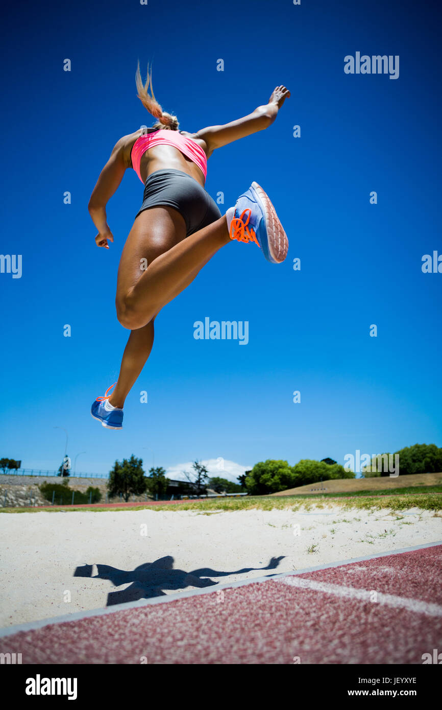 Atleta femminile di eseguire un salto in lungo Foto Stock