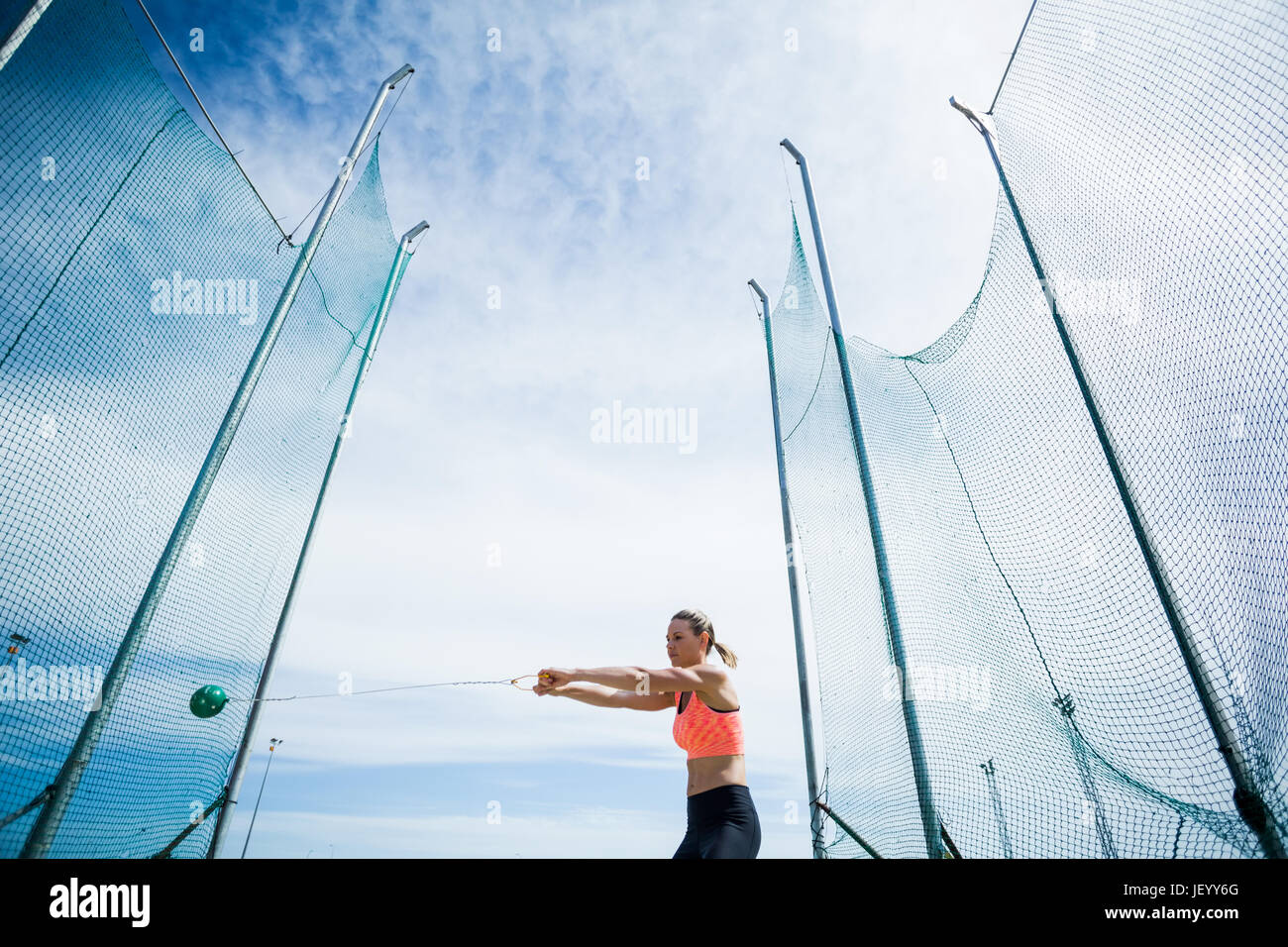 Atleta femminile di eseguire un lancio del martello Foto Stock