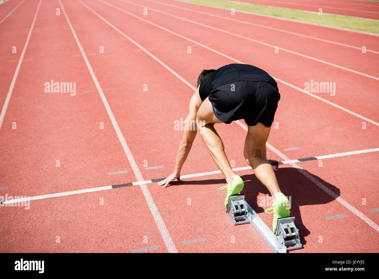 Vista posteriore di un atleta pronto per essere eseguito Foto Stock