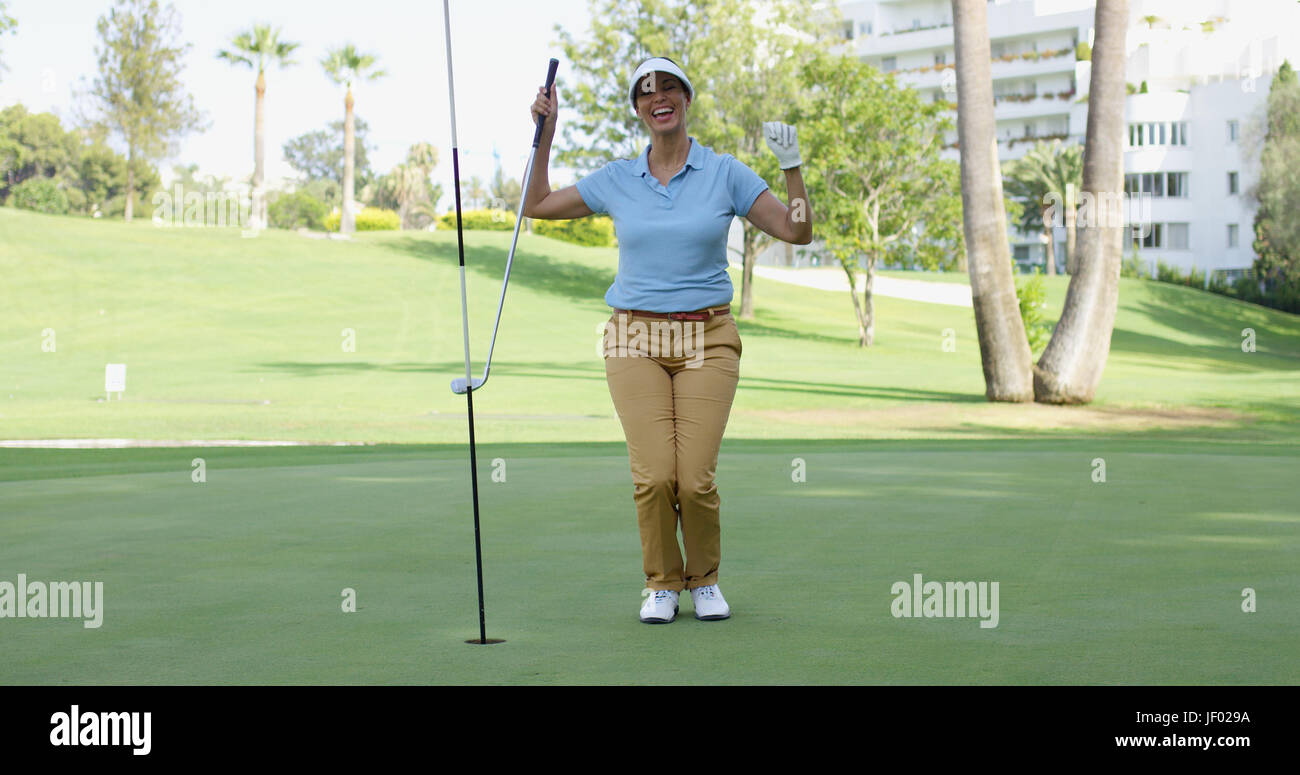 Donna golfista tifo come lei affonda la sua putt Foto Stock