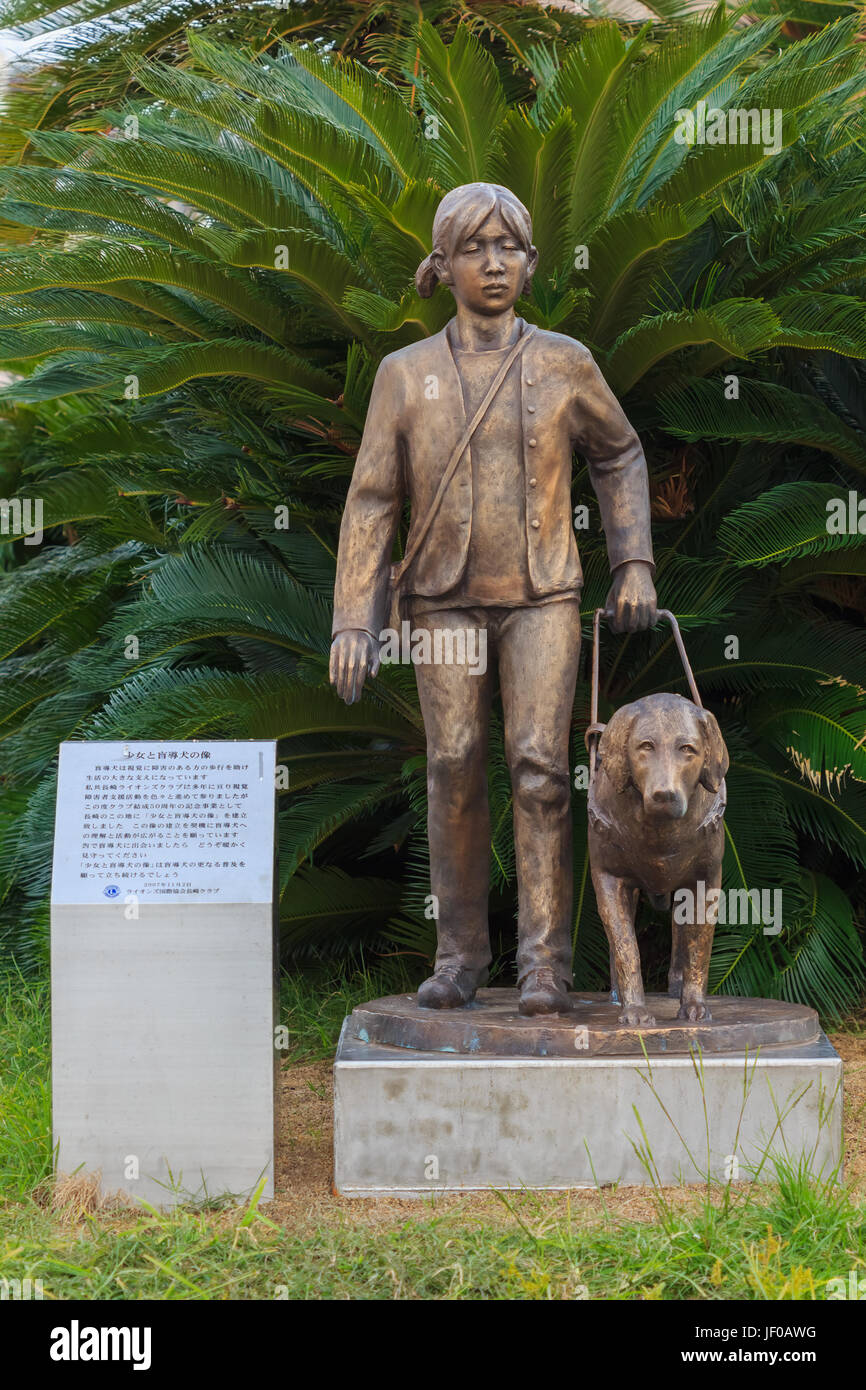 Ragazza cieca e la statua del cane di fronte alla stazione di Nagasaki, di Nagasaki, Giappone Foto Stock
