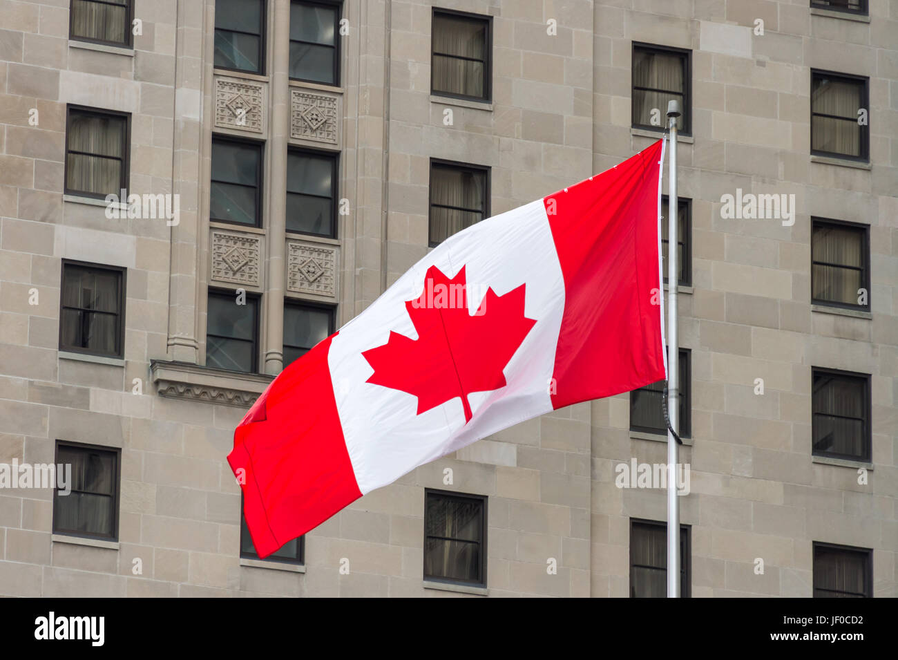 Grande Canada bandiera sventolare nel vento con una parete in background Foto Stock