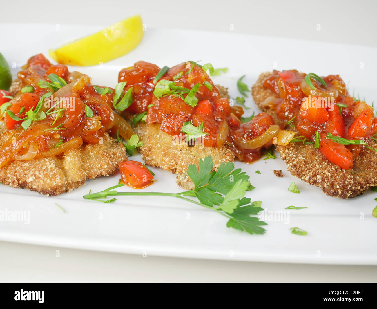 La frittura di pesce aringhe con salsa di pomodoro su una piastra Foto Stock