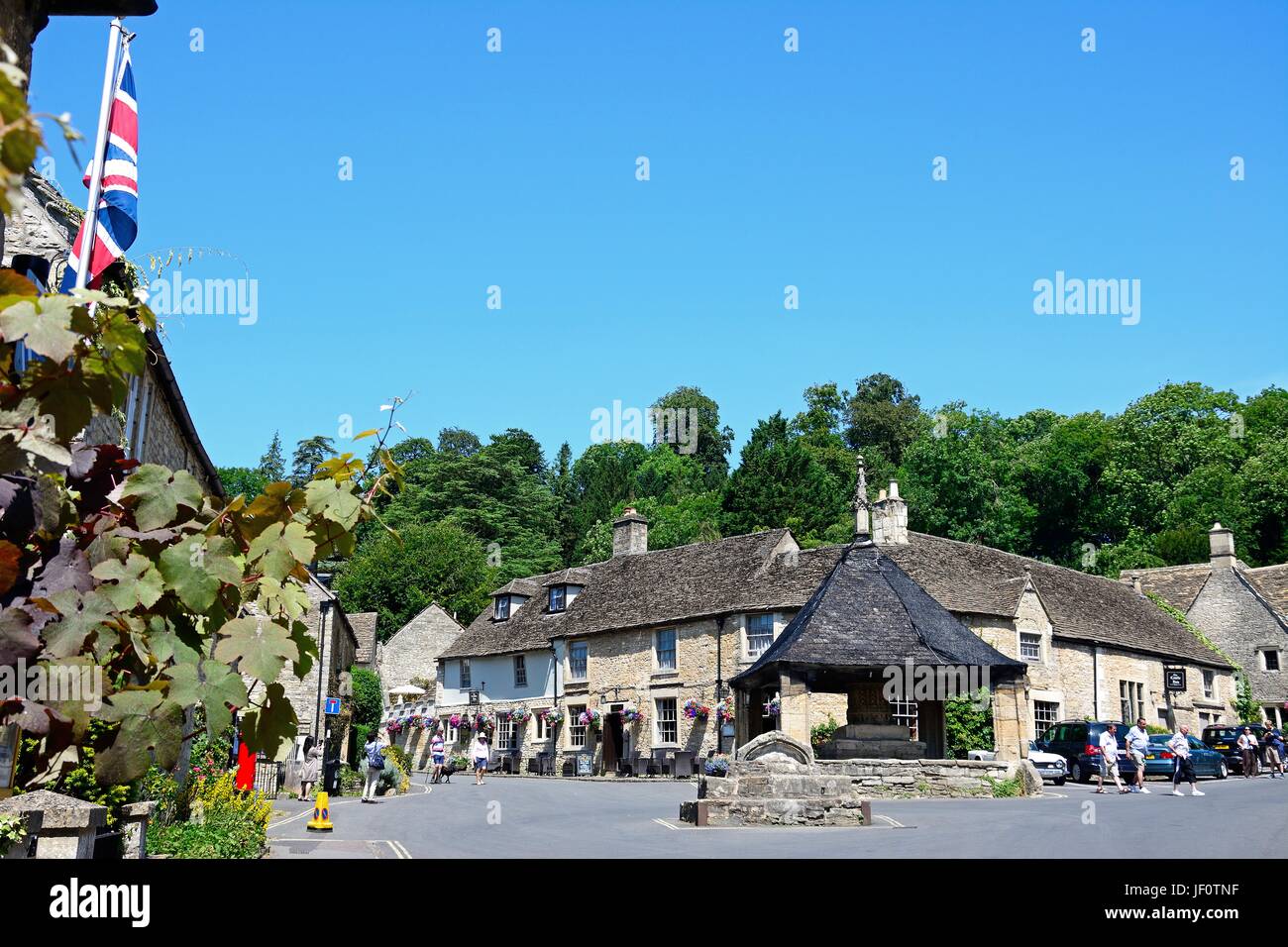 Vista del quattordicesimo secolo croce di mercato con il Castle Inn per la parte posteriore nel centro del villaggio, Castle Combe, Wiltshire, Inghilterra, Regno Unito, Western Europ Foto Stock
