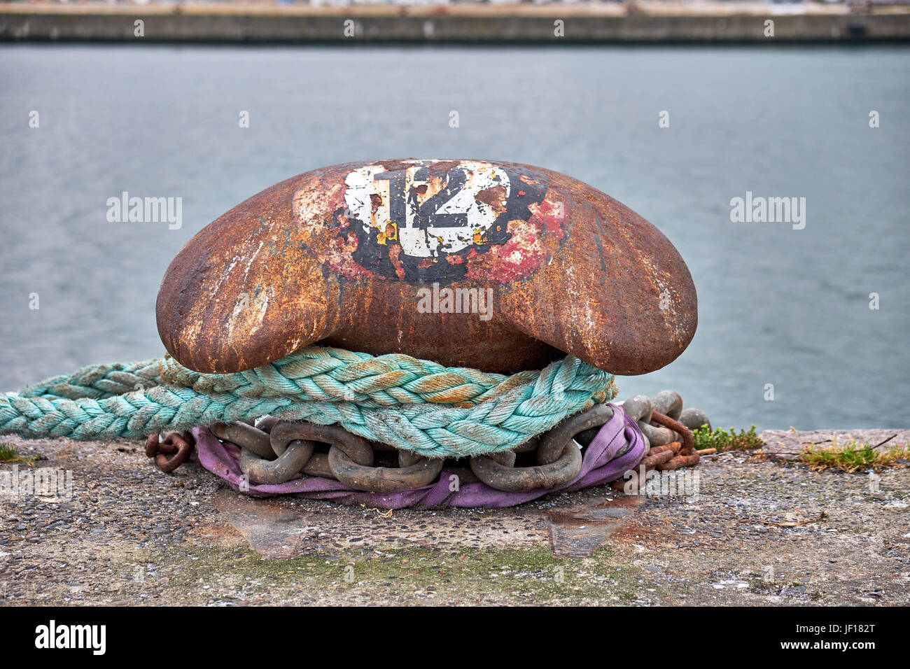 Rusty ormeggio post sulla banchina del porto di Aarhus in Danimarca con il numero 12 dipinta su in un cirkel Foto Stock