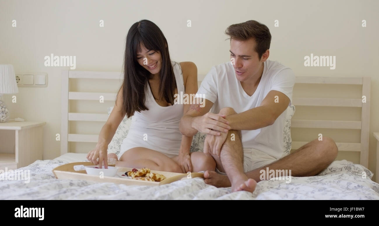 Coppia giovane avente la colazione a letto Foto Stock