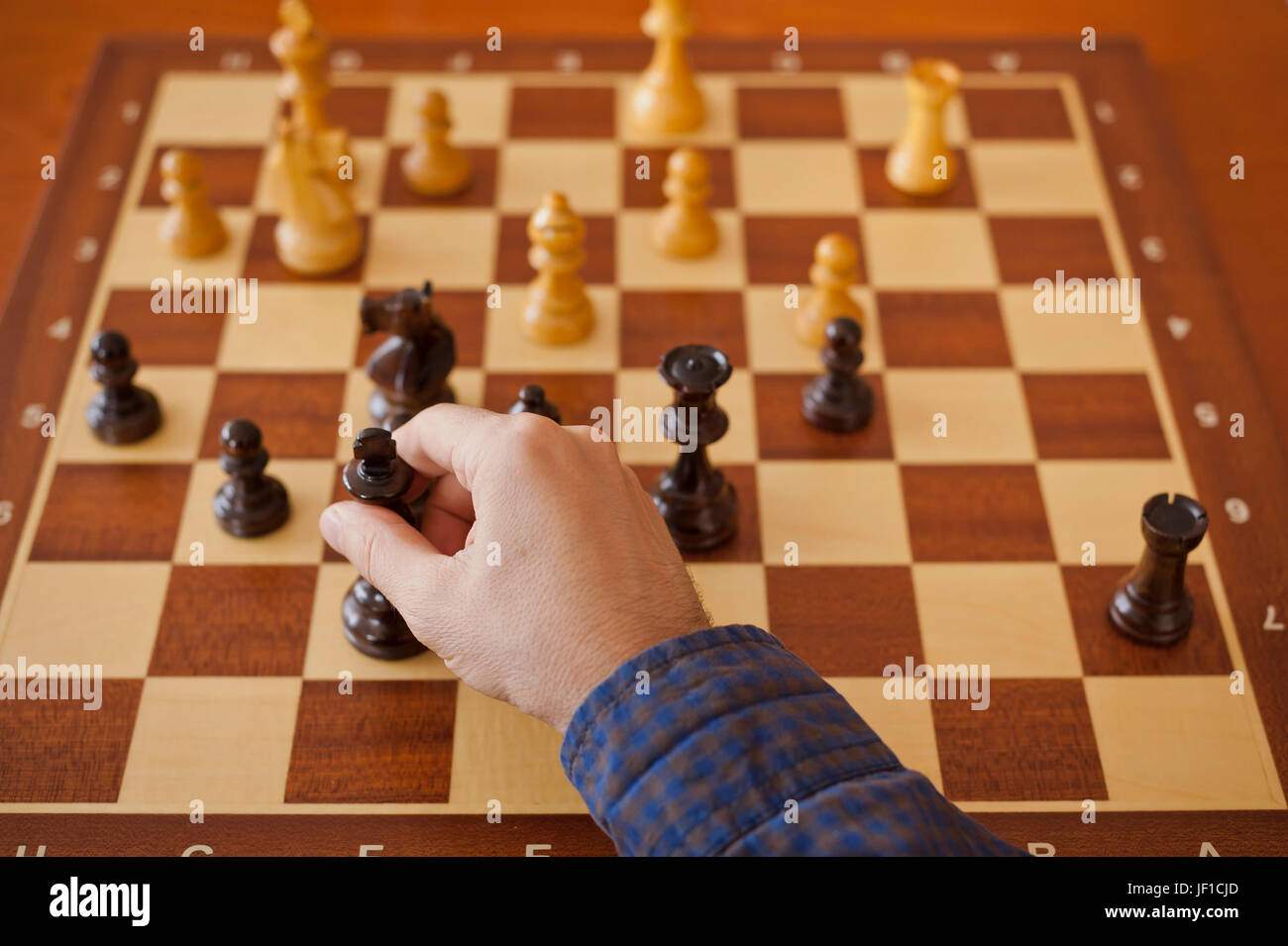 Maschio lato rendendo un re a scacchi spostare Foto Stock