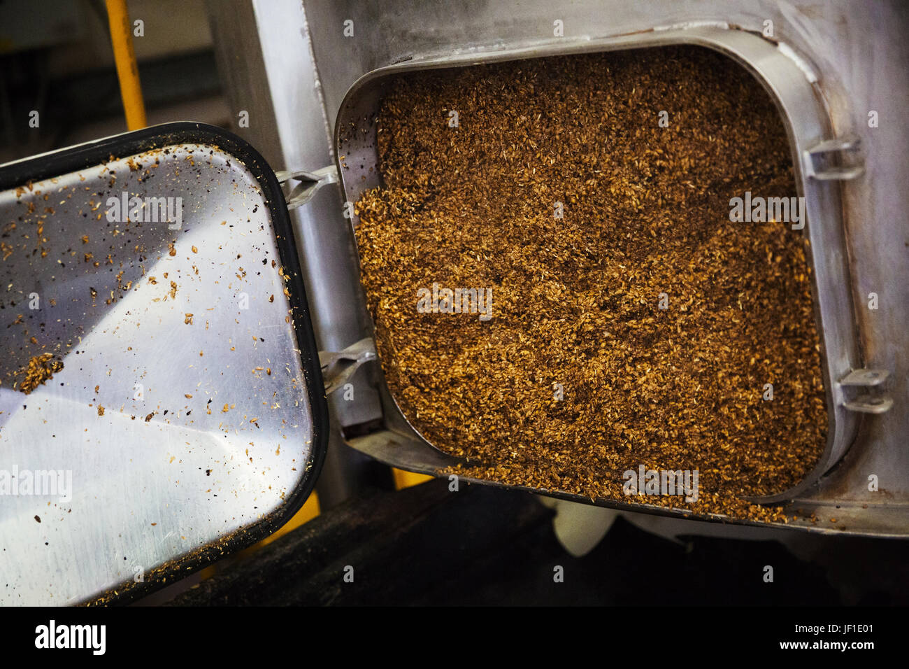 Aprire lo sportello di un grande in acciaio inox bollitore contenente trascorso il grano in una birreria. Foto Stock
