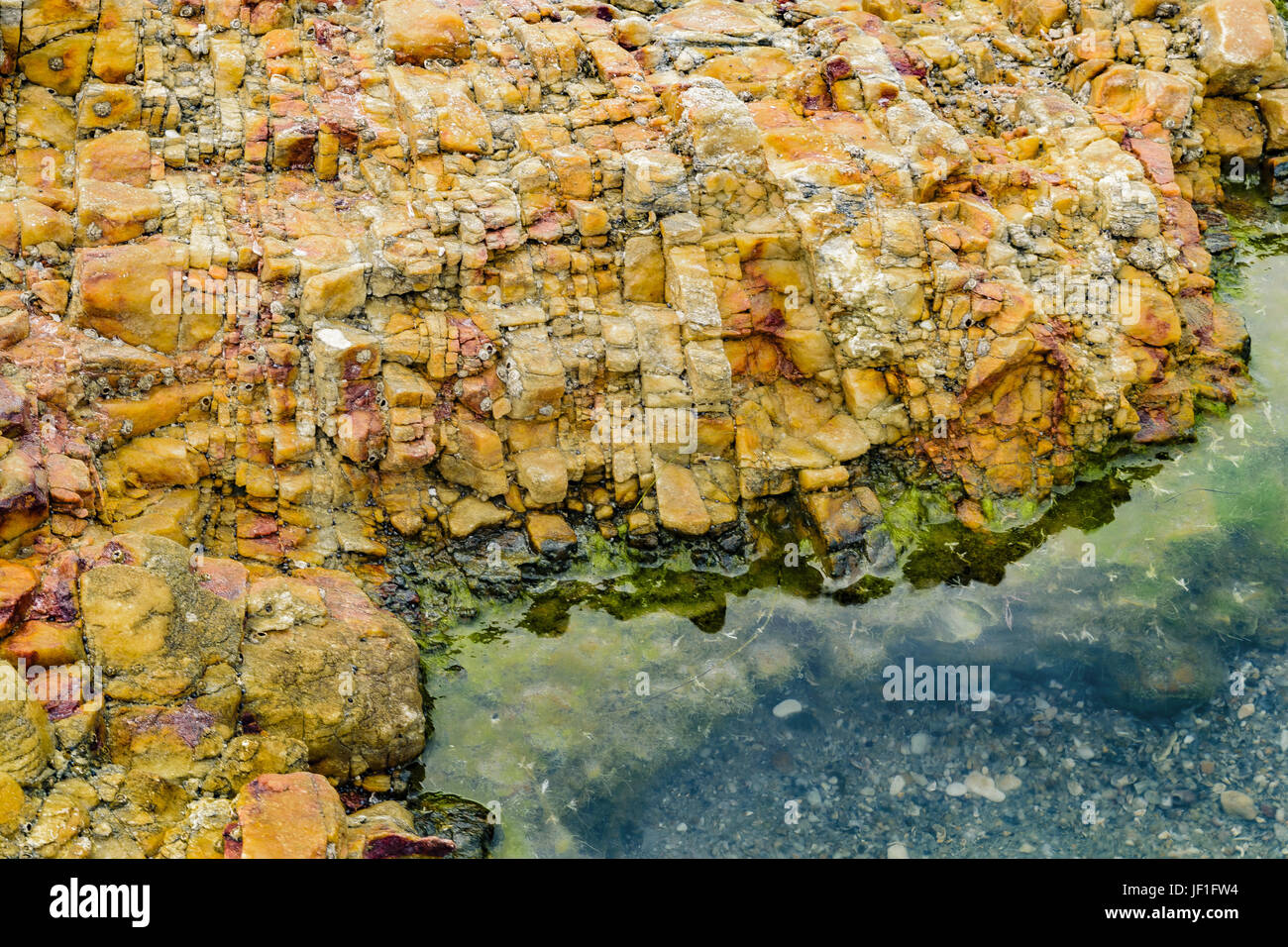 Rocce colorate a riva della spiaggia Foto Stock