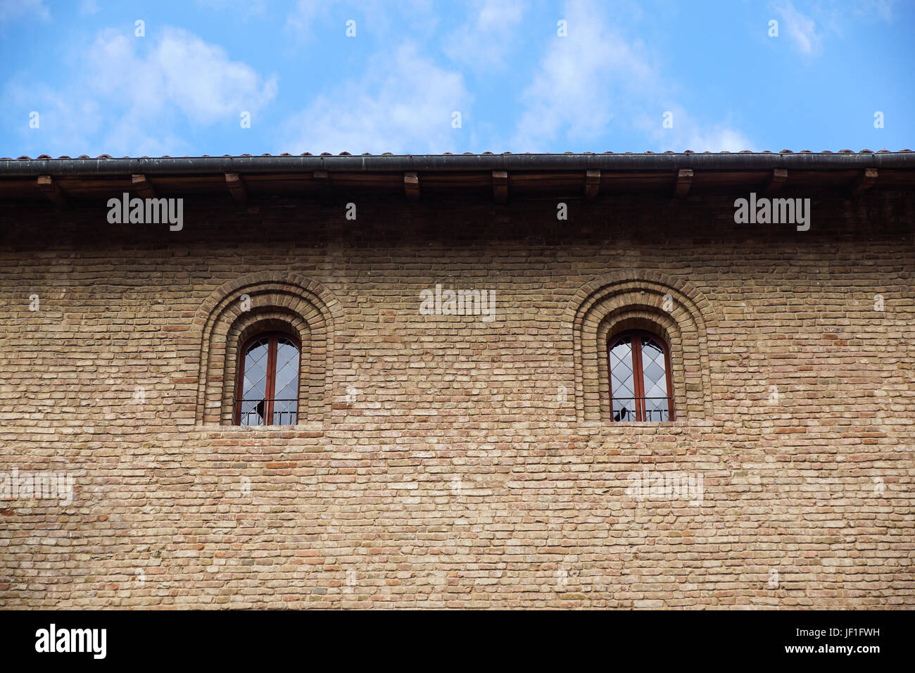 Finestra del castello in stile medievale. Doppia finestra ad arco su una facciata del muro medievale. Biforium - finestra antica con la colonna, vecchia architettura elemento del romano e gotico. Foto Stock