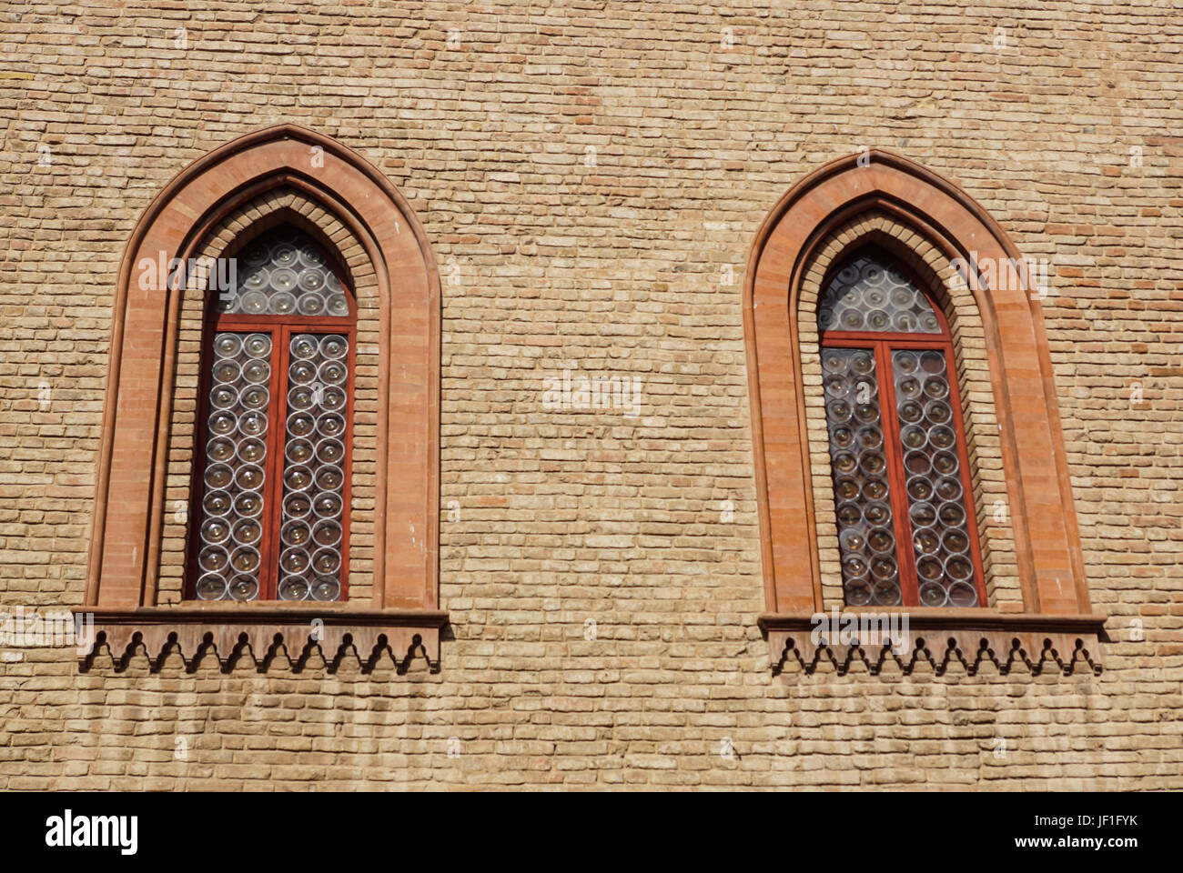 Finestra del castello in stile medievale. Doppia finestra ad arco su una facciata del muro medievale. Biforium - finestra antica con la colonna, vecchia architettura elemento del romano e gotico. Foto Stock