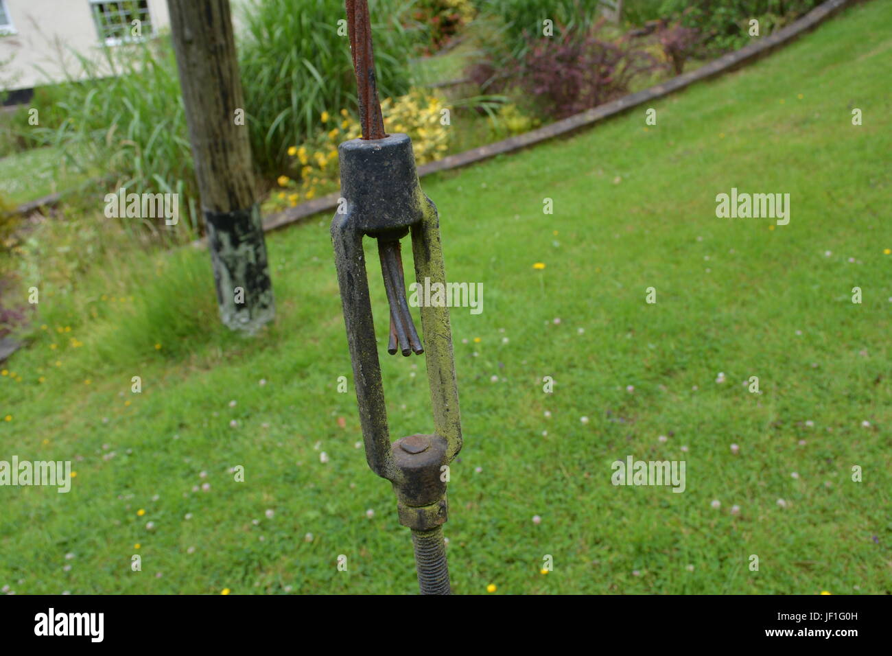 Il tensionamento della fascetta per cavi di energia elettrica per la pole nel giardino sulla pendenza erbosa sito re National Grid di alimentazione Inghilterra REGNO UNITO Foto Stock