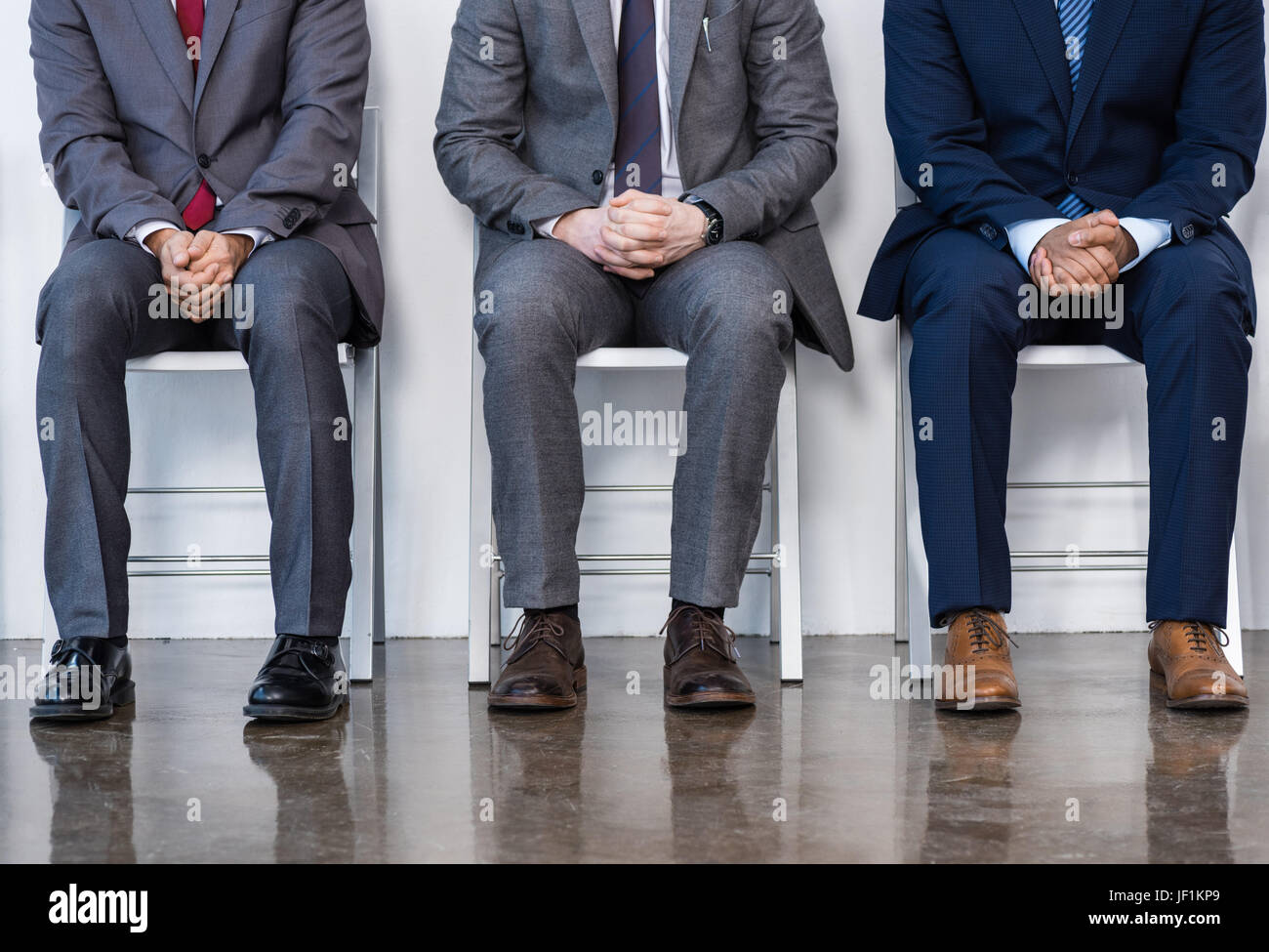 Uomini d'affari in giacca seduti su sedie in bianco in sala d'attesa. business meeting Foto Stock