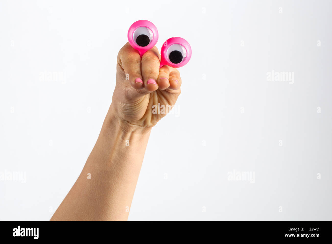 Il carattere divertente creatura cercando scettici raffigurata con mano femminile e googly gli occhi. Isolato su bianco con spazio di copia Foto Stock