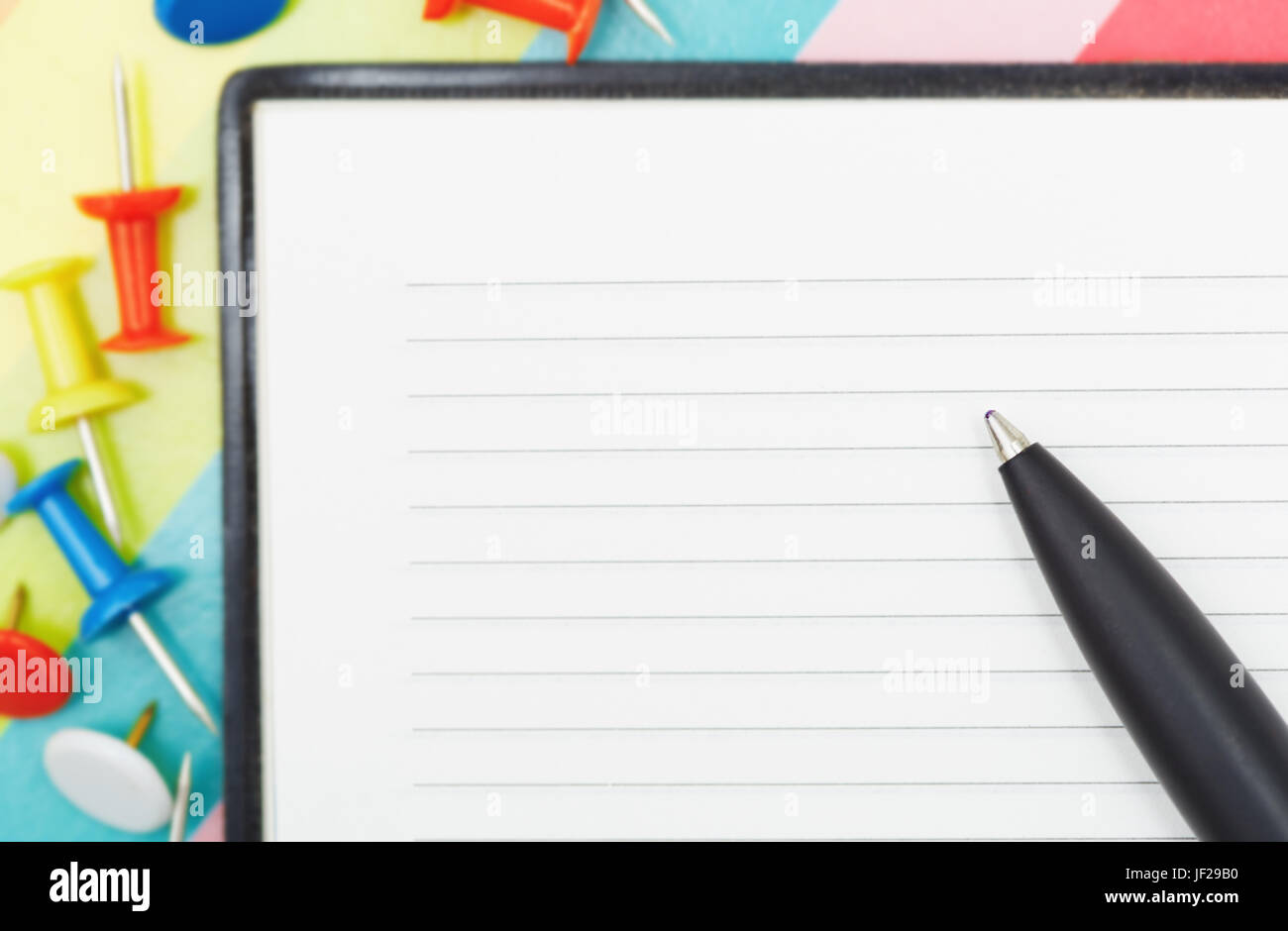 Blocco note con penna e puntine Foto Stock