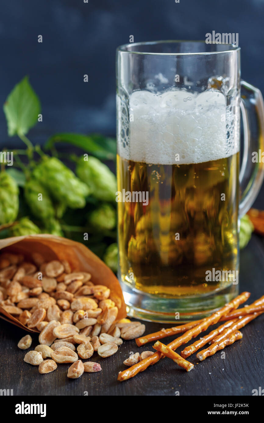 Bastoncini salati, arachidi e bicchiere di birra. Foto Stock