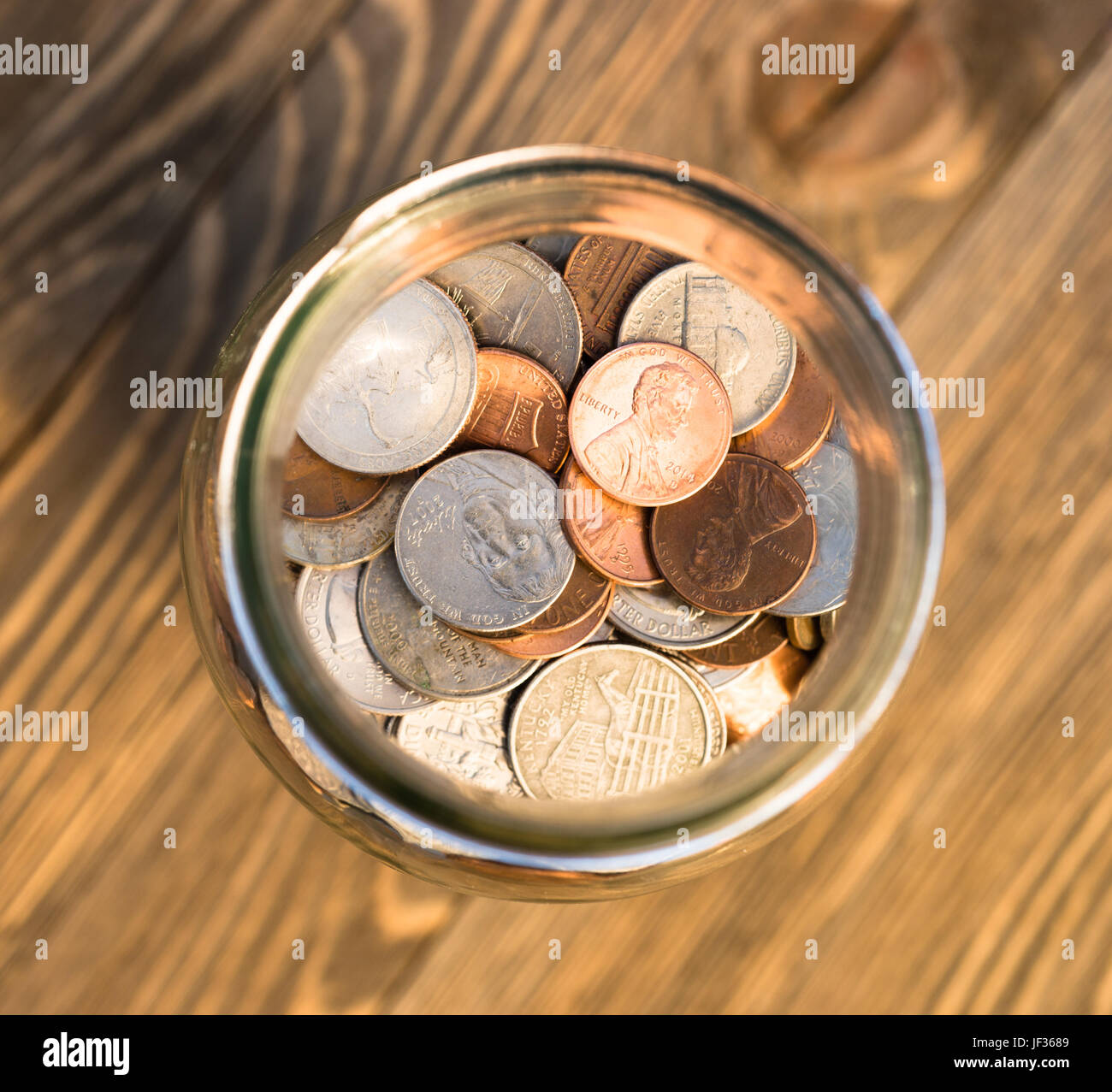 Una selezione delle monete contenute in un vasetto di vetro Foto Stock