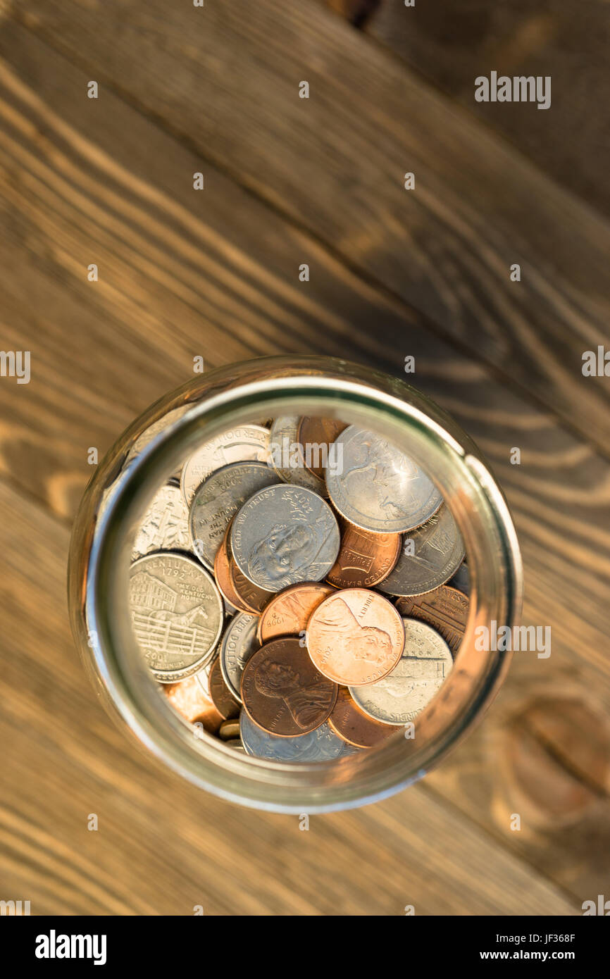 Una selezione delle monete contenute in un vasetto di vetro Foto Stock