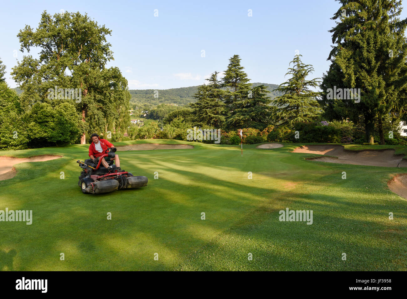 Magliaso, Svizzera - 2 Giugno 2017: Uomo su una macchina per la manutenzione del campo da golf di Magliaso sulla Svizzera Foto Stock