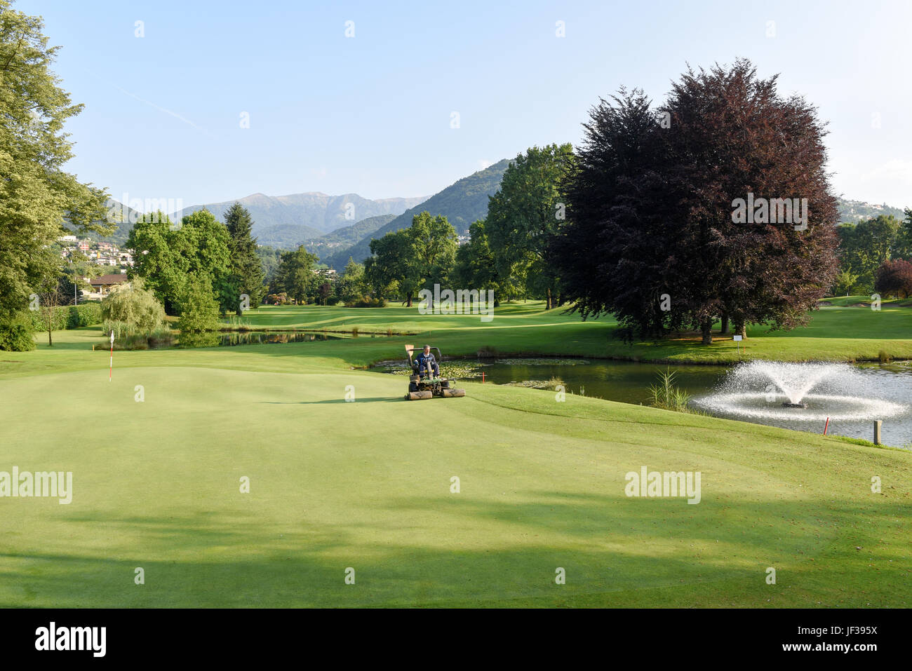 Magliaso, Svizzera - 2 Giugno 2017: Uomo su una macchina per la manutenzione del campo da golf di Magliaso sulla Svizzera Foto Stock
