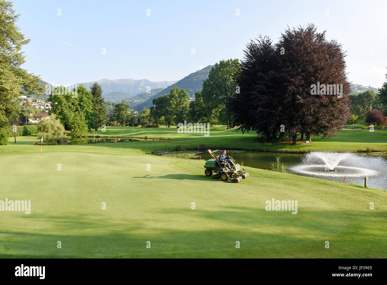 Magliaso, Svizzera - 2 Giugno 2017: Uomo su una macchina per la manutenzione del campo da golf di Magliaso sulla Svizzera Foto Stock