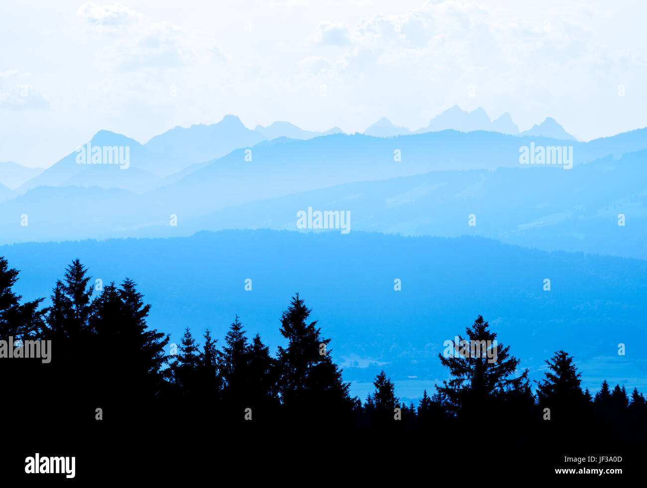 Vista spettacolare delle gamme della montagna di sagome in blu crepuscolo ora Foto Stock