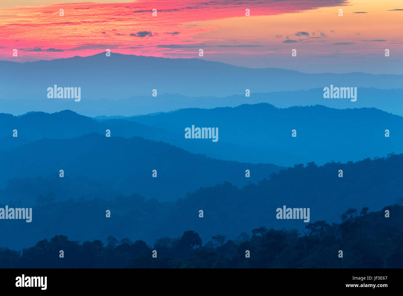 Strato di montagne nella nebbia al tramonto del tempo con la masterizzazione di sky, Nan Provincia, Thailandia Foto Stock