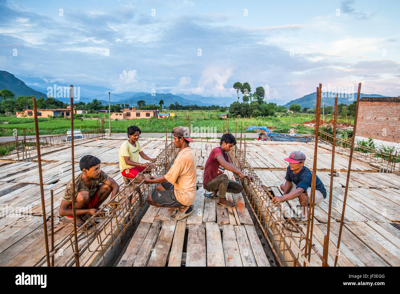 Giovani uomini che lavorano con rebar quando la costruzione di una casa nel distretto di Nuwakot, Nepal Foto Stock