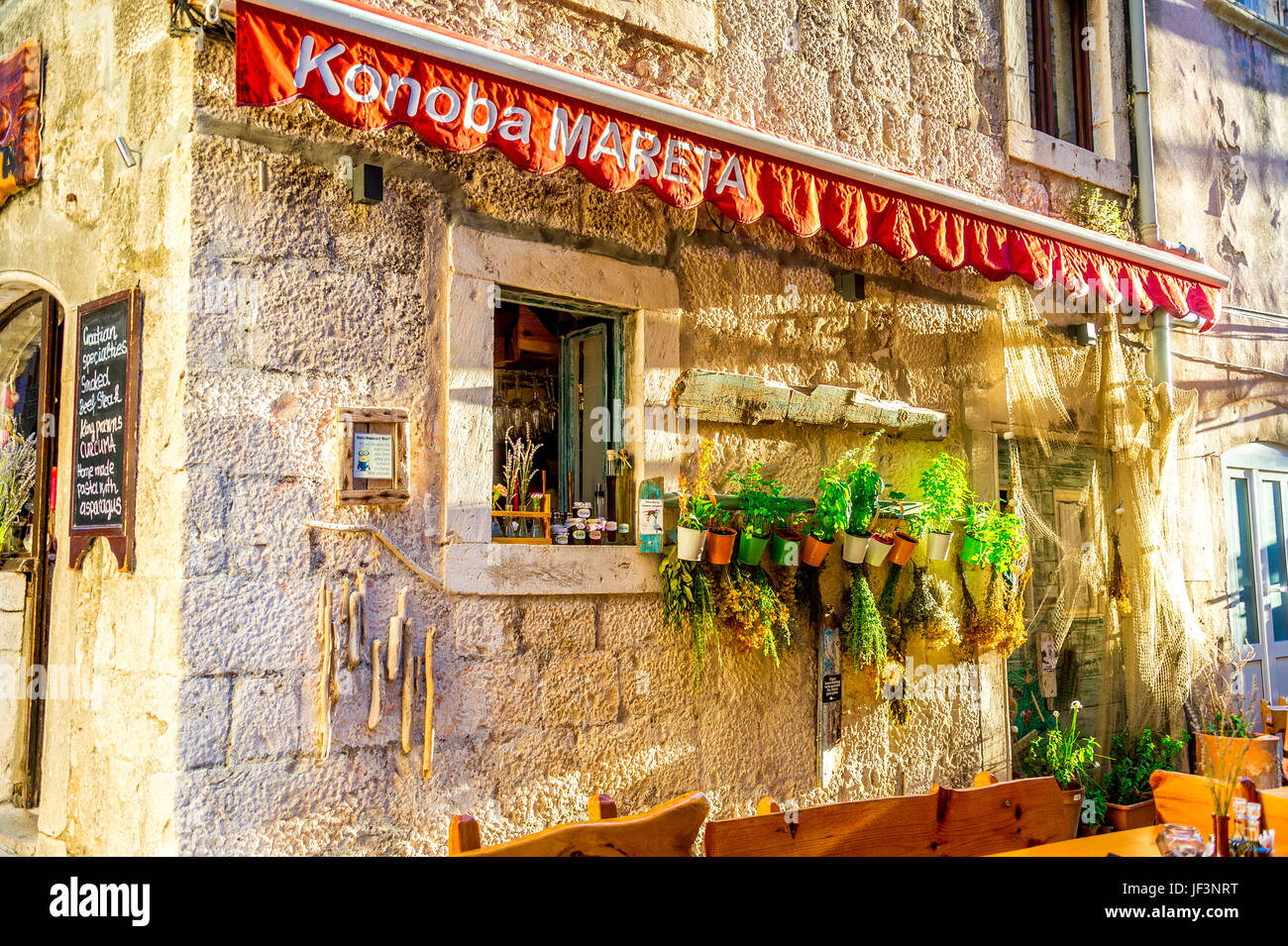Un negozio di fronte alla città vecchia è fiancheggiata da piante sulle pareti di pietra nella città di Korcula, in Croazia Foto Stock
