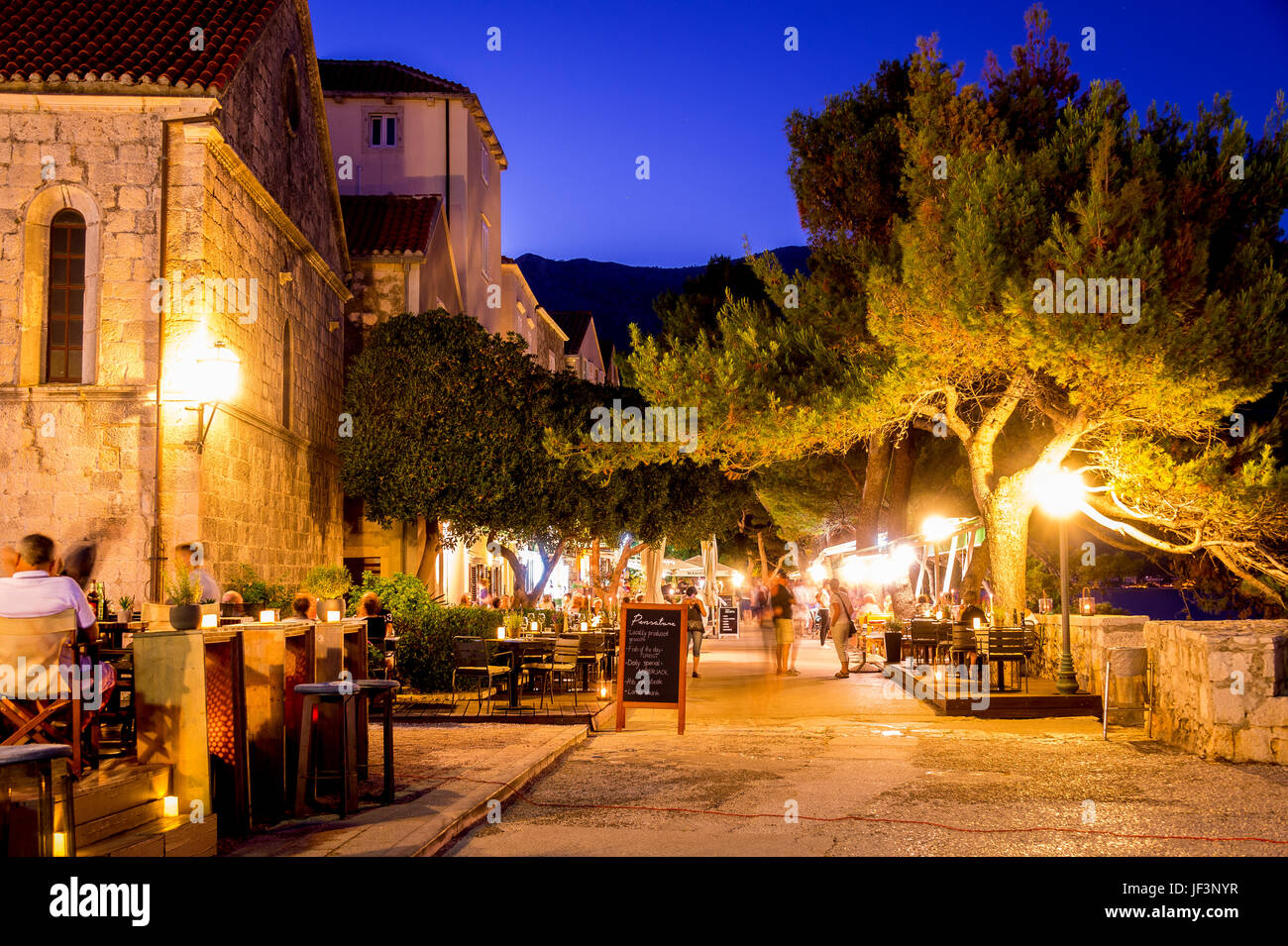 Notte e i ristoranti della Città Vecchia che costeggiano il lungomare di Zakerjan sulla cima del Muro della Città Est nella città vecchia di Korcula, Croazia Foto Stock