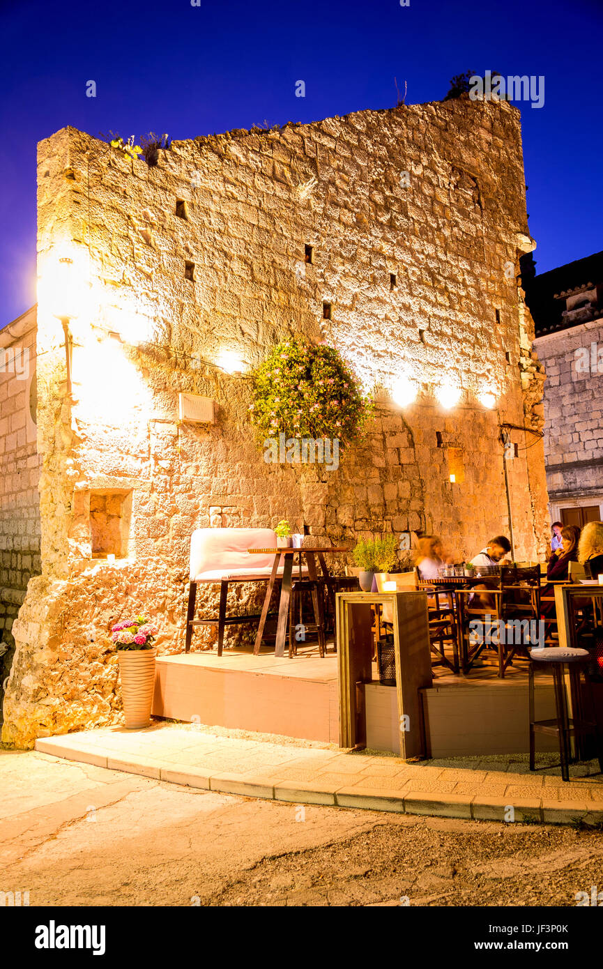 Notte e i ristoranti della Città Vecchia che costeggiano il lungomare di Zakerjan sulla cima del Muro della Città Est nella città vecchia di Korcula, Croazia Foto Stock